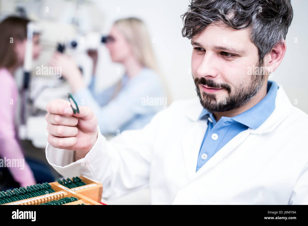 Optiker halten Objektiv im Shop. Stockfoto