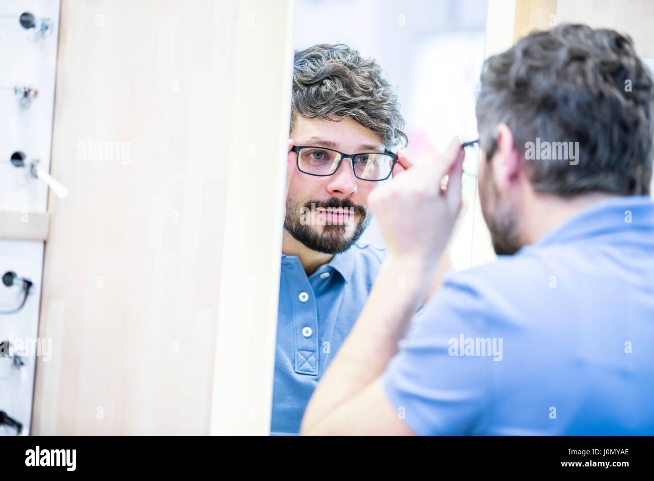 Mann, der versucht auf Gläsern im Optiker Shop. Stockfoto
