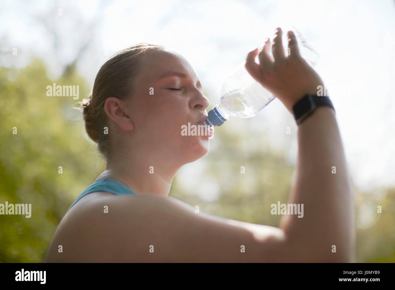 Frau trinkt aus Flasche Wasser. Stockfoto