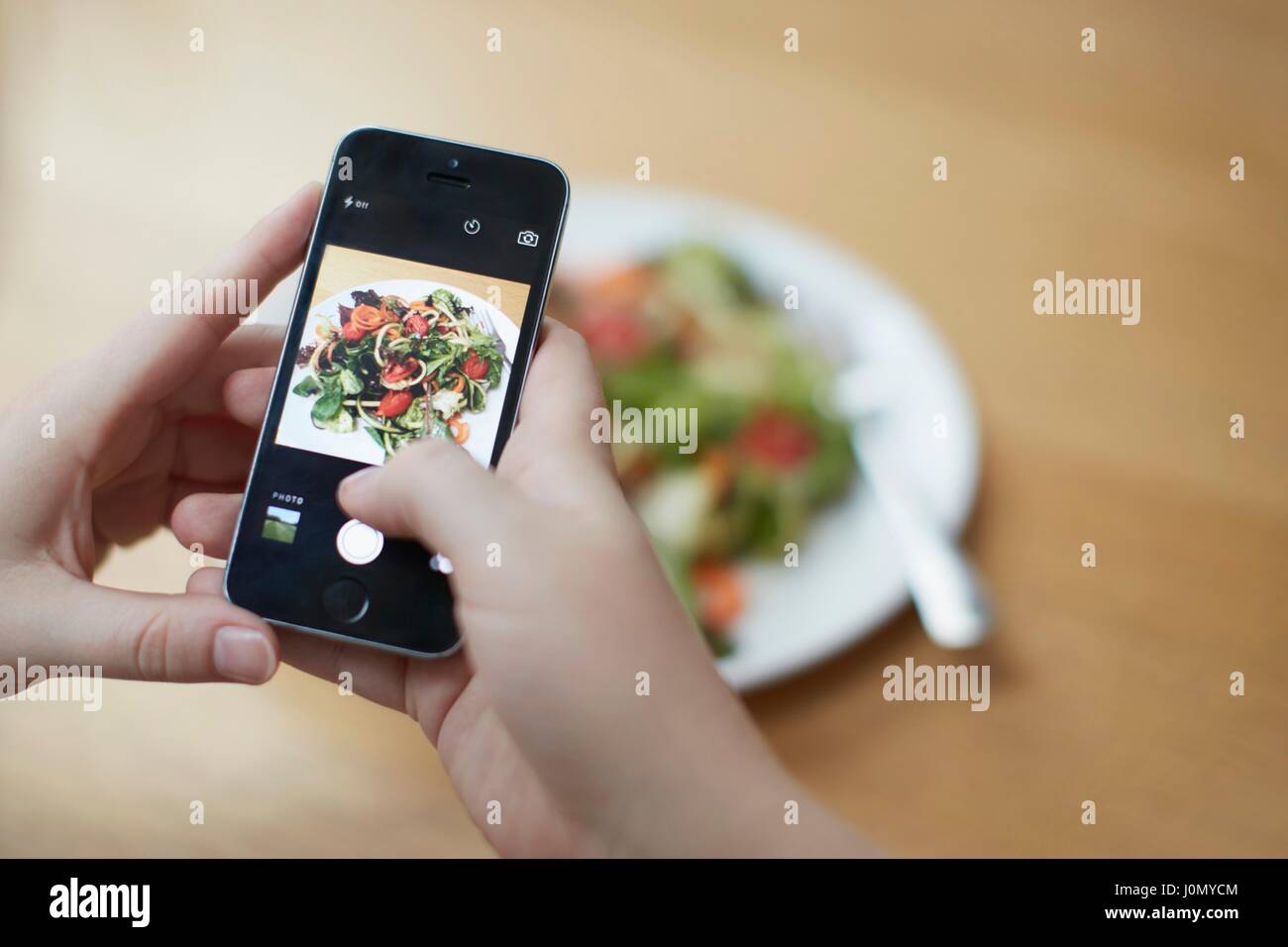 Frau nehmen Foto von Lebensmitteln mit Smartphone, Kalorien zu überprüfen. Stockfoto