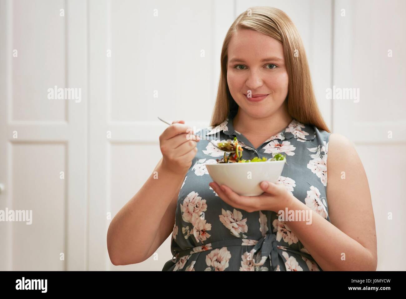 Junge Frau Schüssel Salat zu essen. Stockfoto