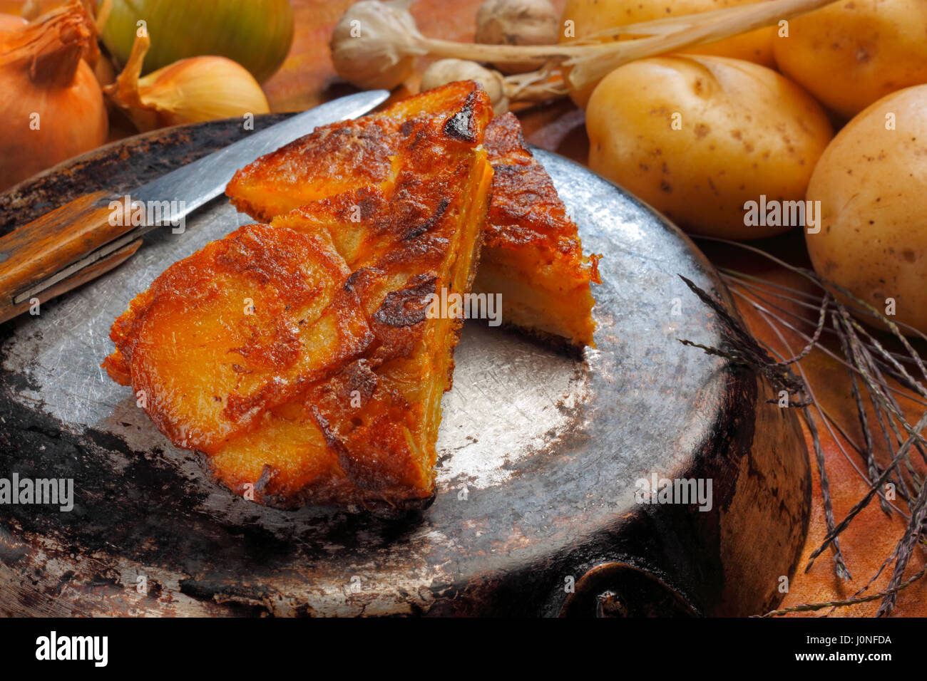 Stillleben mit zwei Stücken von Tortilla Espanola (spanisches Omelett mit Kartoffeln und Zwiebeln) liegen über invertiert Pfanne Stockfoto