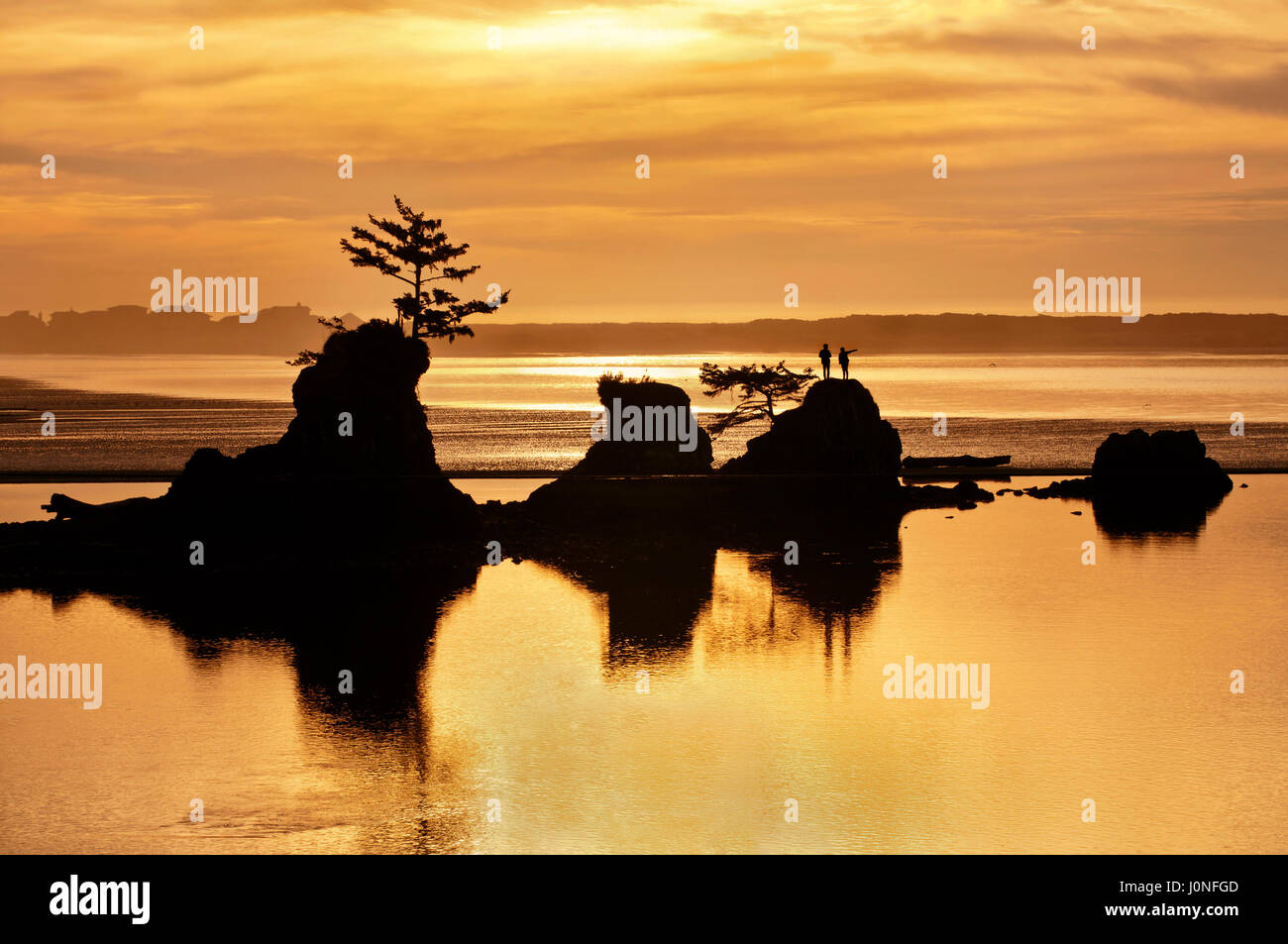 Sonnenuntergang von Ocean Beach mit Felsformationen und Goldtönen des Lichts Stockfoto