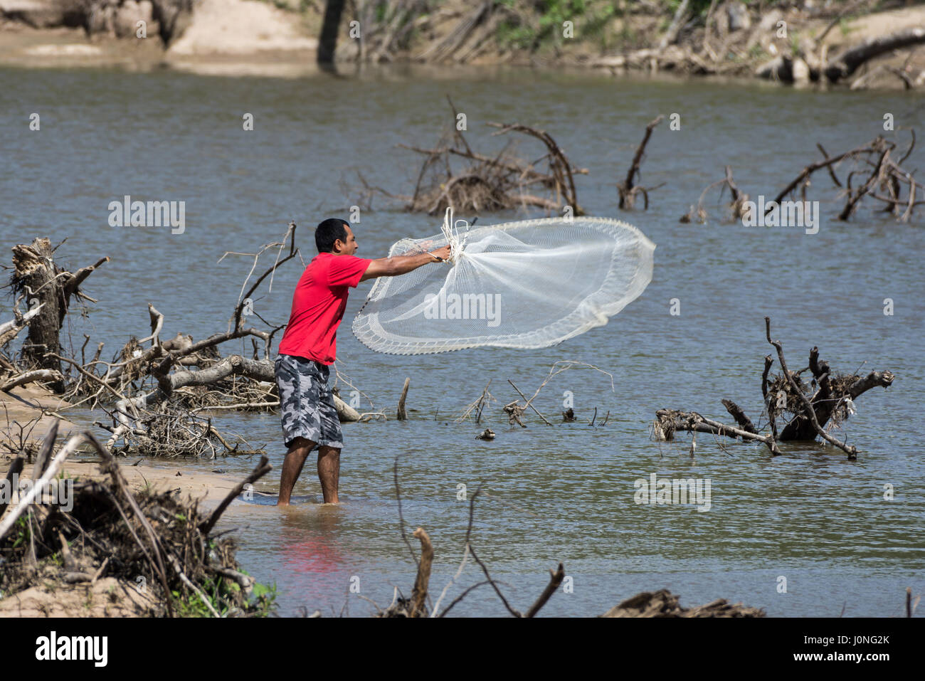 Ein Mann von einem Fluss mit einem Netz fischen. Texas, USA Stockfoto