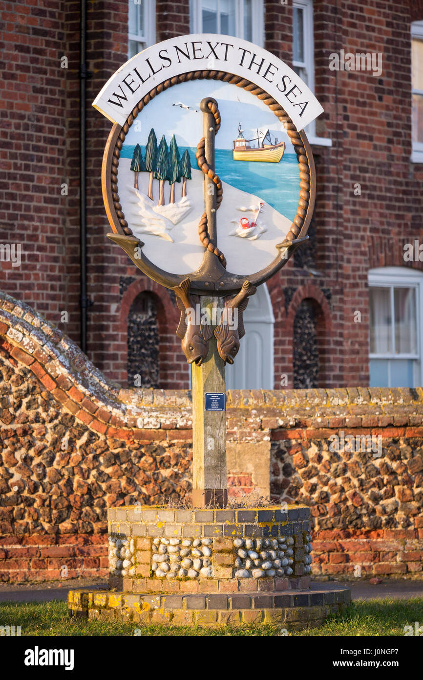 Brunnen als nächstes das Meer - einer der traditionellen gemalten Dorf signiert von traditionellen Backstein und Flint Mauer in North Norfolk, Großbritannien Stockfoto