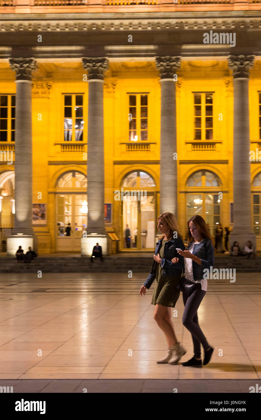 Junge Frauen SMS mit Smartphone durch das Grand Theatre in Place De La Comedie, Bordeaux, Frankreich Stockfoto