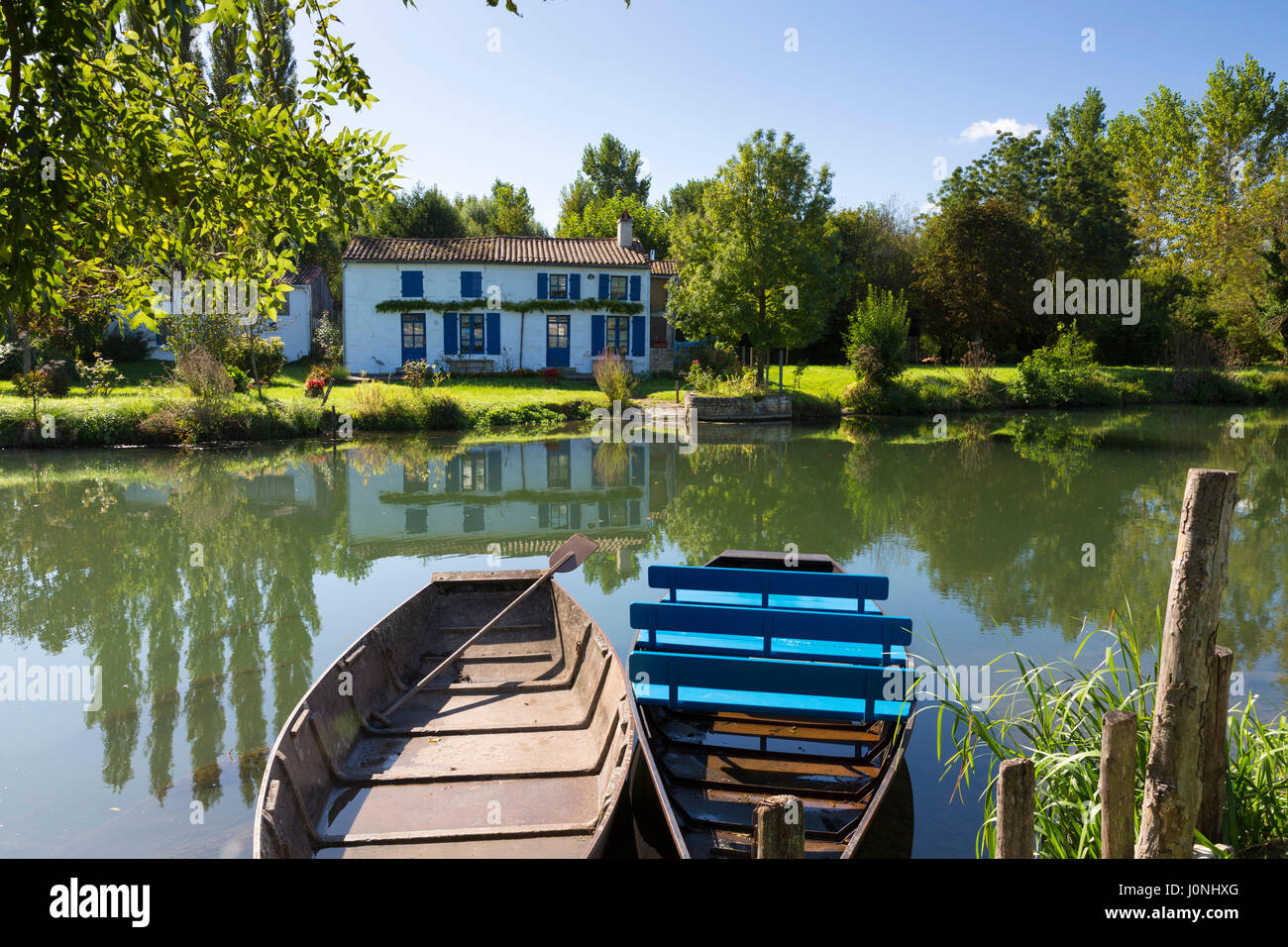 Ruderboote und House Fluss La Sevre-Niortaise in Coulon in Marais Poitrevin Region, Grand Site de France Stockfoto
