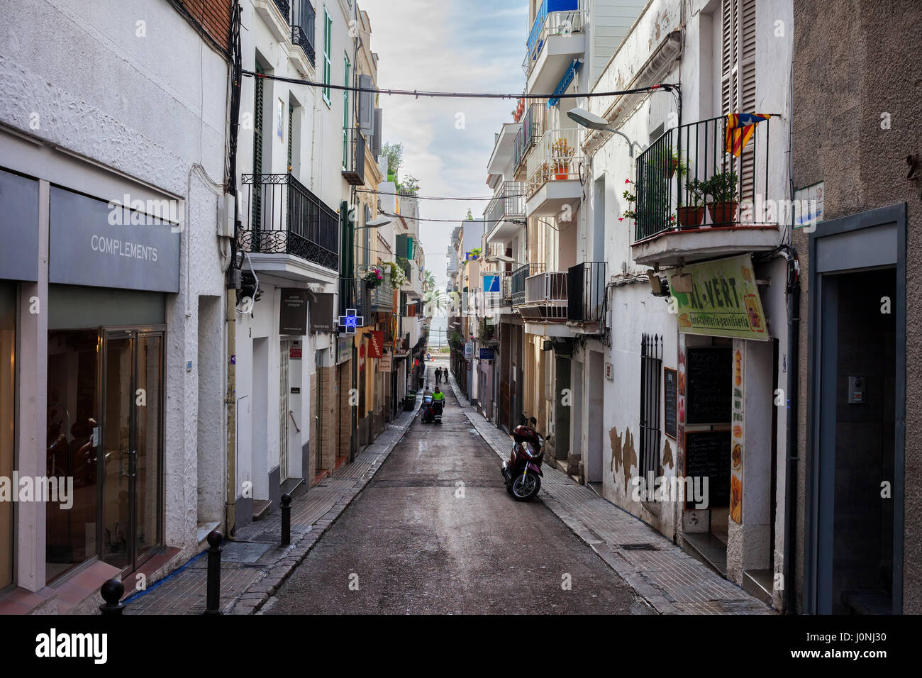 Spanien, Sitges, Küstenstadt in der Region Katalonien, Calle Bonaire schmale Straße mit Blick auf das Meer Stockfoto