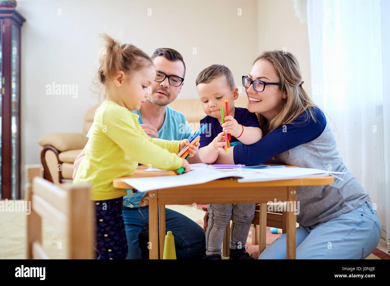 Eltern und Kinder ziehen zusammen auf dem Zimmer Stockfoto