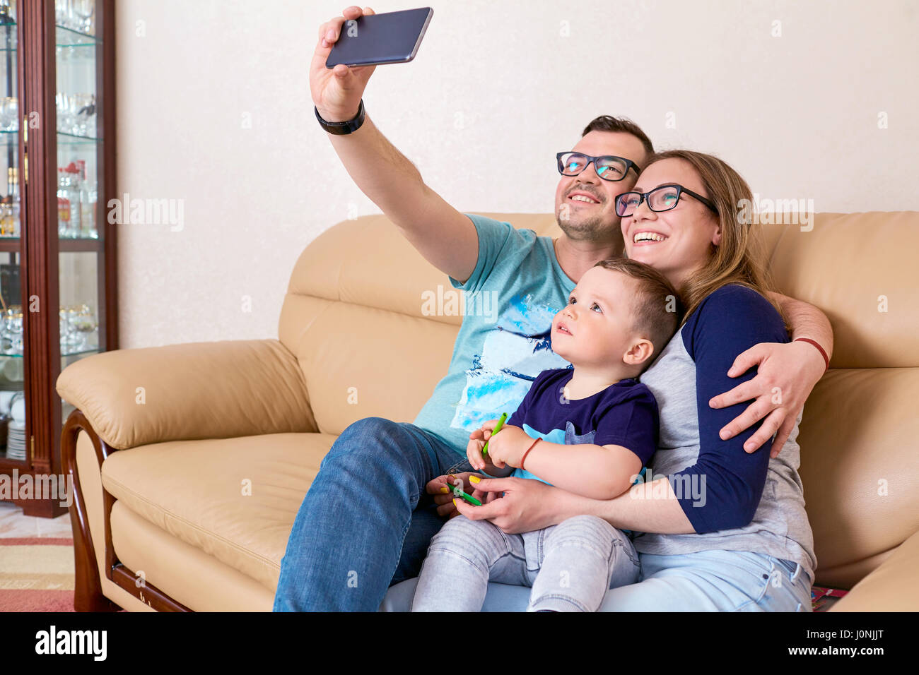 Mutter, Vater und Sohn Lächeln, Selfie am Telefon sitzen auf Stockfoto