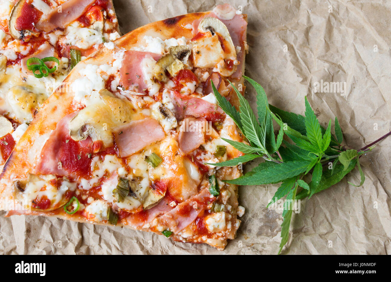 Gerne Pizza Scheiben mit Marihuana hinterlässt auf dem Papier Stockfoto