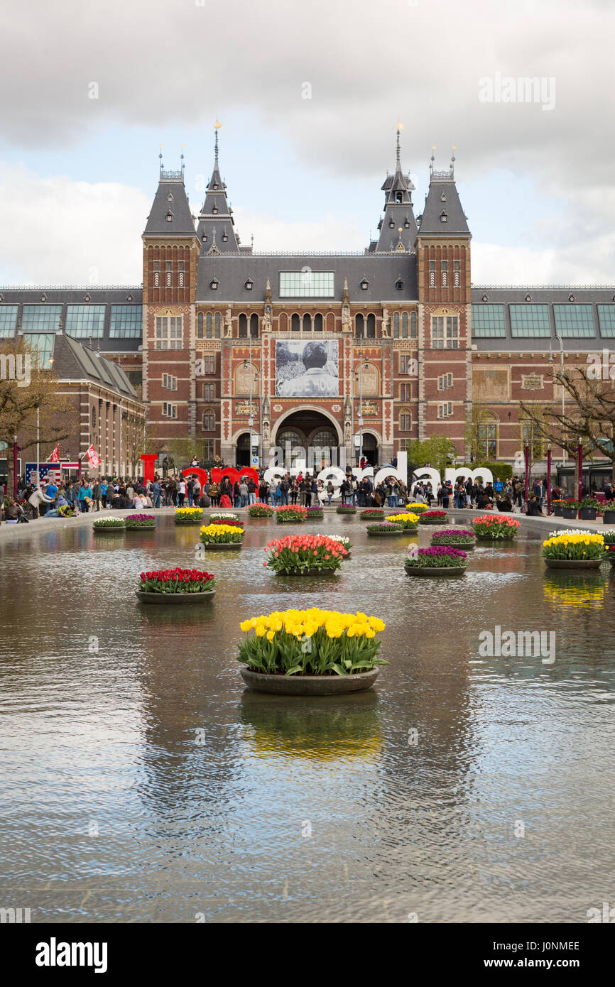 Vorderseite des Rijksmuseums, mit Tulpen im See vor. Amsterdam, Niederlande, Europa. Stockfoto