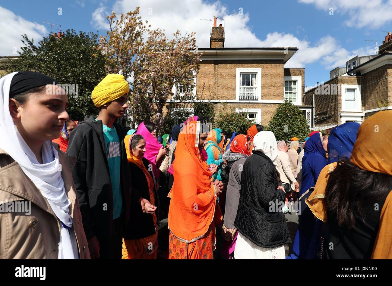 Mitglieder der Sikh Gemeinschaft nehmen an der Nagar Kirtan-Prozession durch Gravesend, Kent, während des Sikh Festivals Vaisakhi. Stockfoto