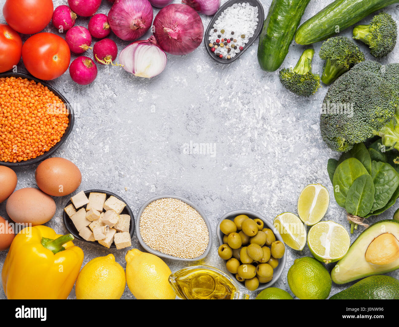 Bunten Nahrung Hintergrund. Vegane Lebensmittelzutaten mit Textfreiraum. Getreide und Gemüse auf grauem Beton Hintergrund. Gesunde Ernährung-Konzept Stockfoto
