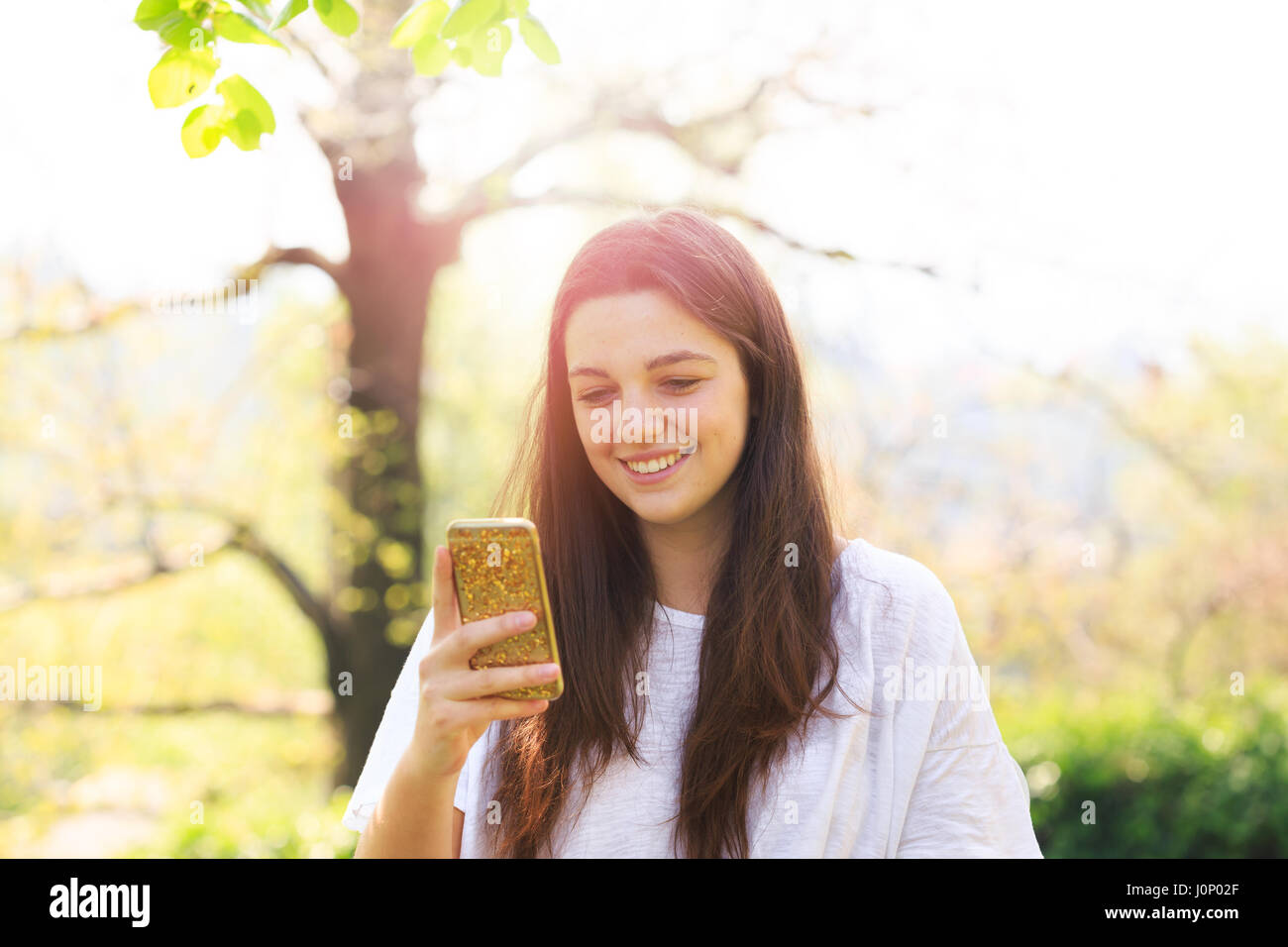 Lächelnde Teenager-Mädchen mit Handy Stockfoto