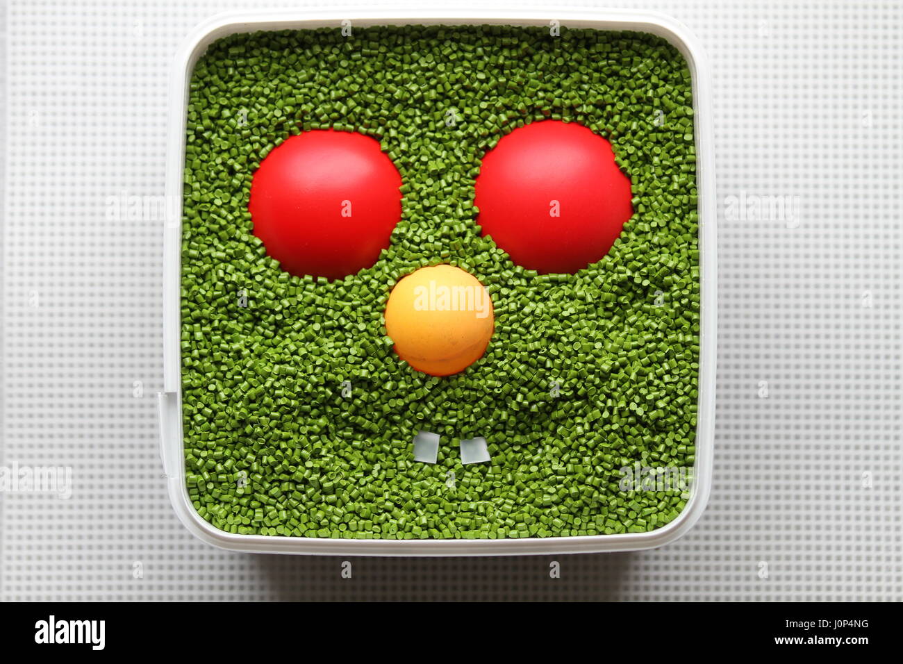 Kreatives Design. Werk des Autors. Lächeln. Kunststoff-Gesicht. Emoticon für den Einsatz in Computerspielen und Webdesign. Grüne Emoticon mit rot und Augen gelben Nase. Stockfoto