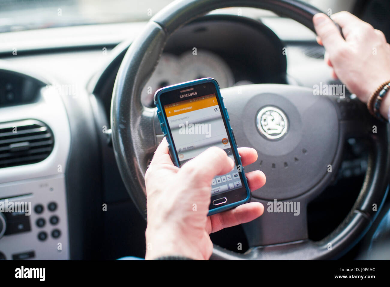 Mann mit Handy-SMS während der Fahrt Stockfoto