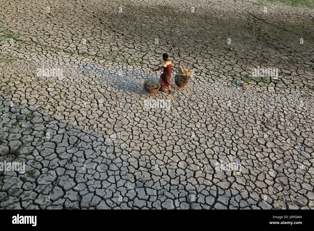 Ein Kreditor durchläuft eine Dürre ausgetrocknet Feld Beraid unter Dhakas Bhatara. Bangladesch Stockfoto