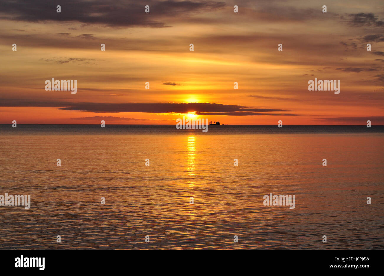 Hellen goldenen Sonnenaufgang über der Ostsee in Polen mit einem Schiff am Horizont Stockfoto