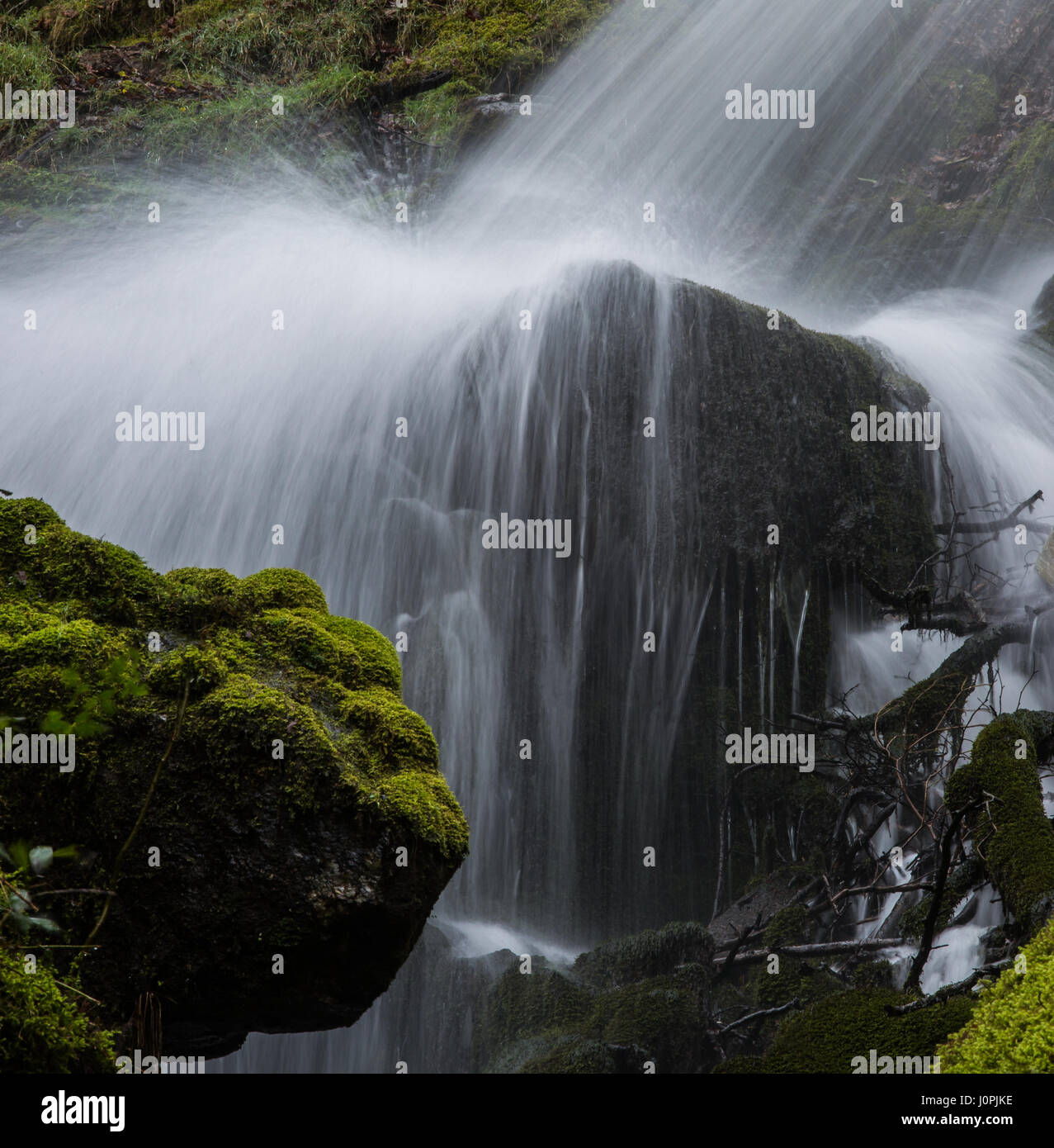 Wasserfall in Strömen über einen großen Klumpen aus Granit. Stockfoto