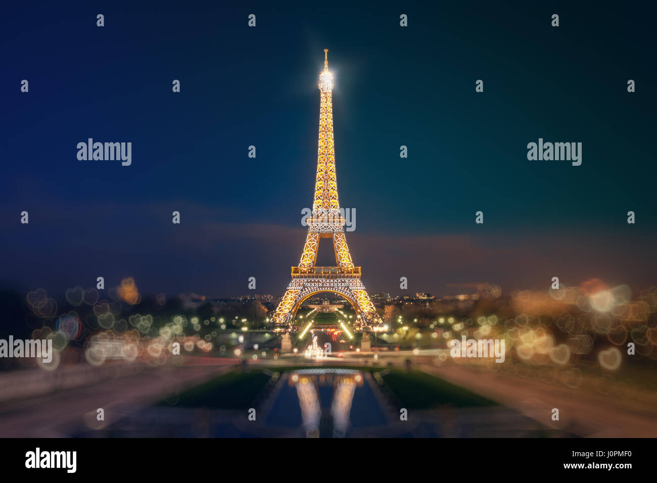 Eiffelturm, Trocadero-Gärten zu sehen. Beleuchteten Eiffelturm spiegelt sich auf dem Wasser der Brunnen Tracadero Abend. Bokeh in der Form einer h Stockfoto