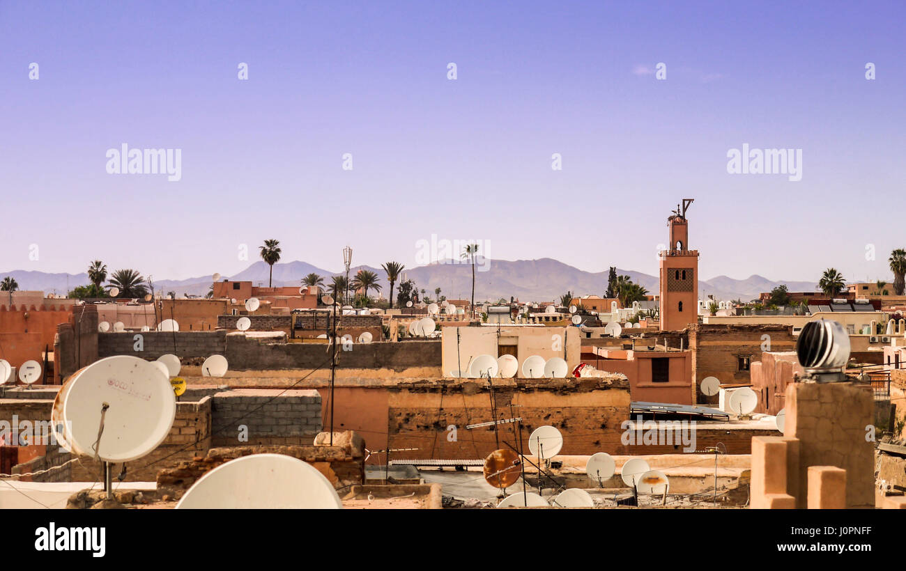 Blick über die Häuser in der alten Medina in Marrakesch mit dem Atlas-Gebirge im Hintergrund Stockfoto