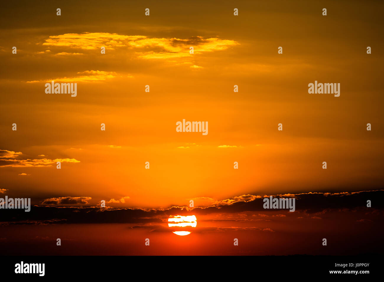 Ein goldener Horizont füllt einen perfekten Sonnenuntergang Stockfoto