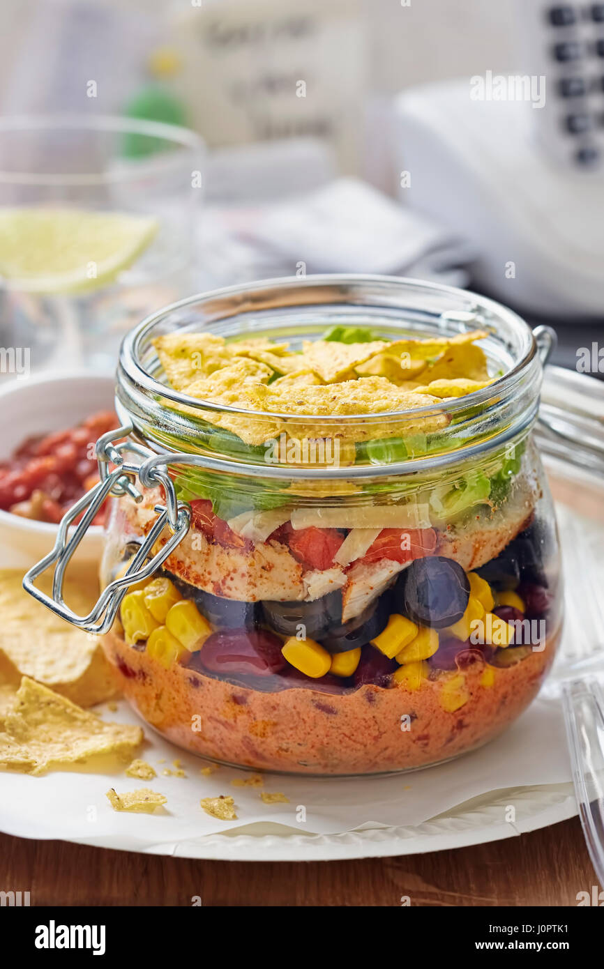 Geschichtete mexikanisches Sandwich Glas mit Mais, schwarze Bohnen, Salat,  Käse, Paprika, Kopfsalat und Tortilla chips Stockfotografie - Alamy