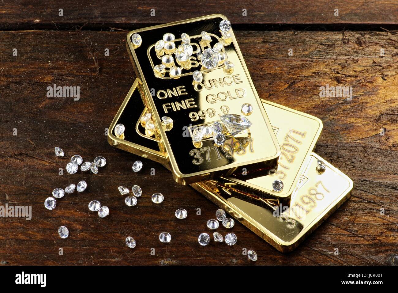Goldbarren und Diamanten auf hölzernen Hintergrund Stockfoto
