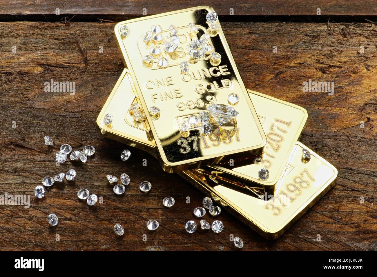 Goldbarren und Diamanten auf hölzernen Hintergrund Stockfoto