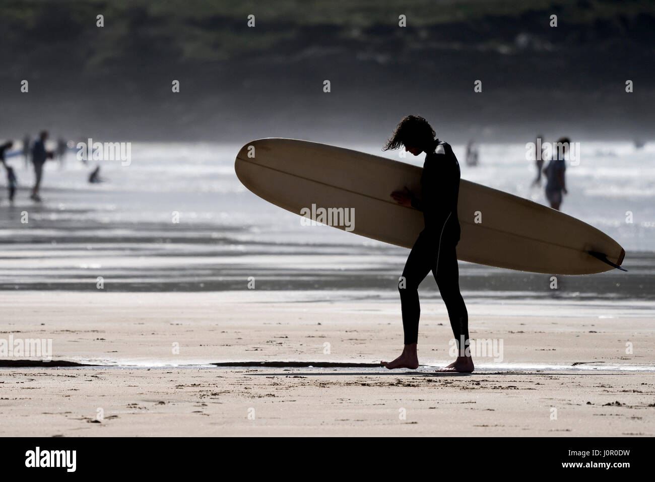 UK Surfen - die Silhouette eines Surfer aus dem Meer. Stockfoto