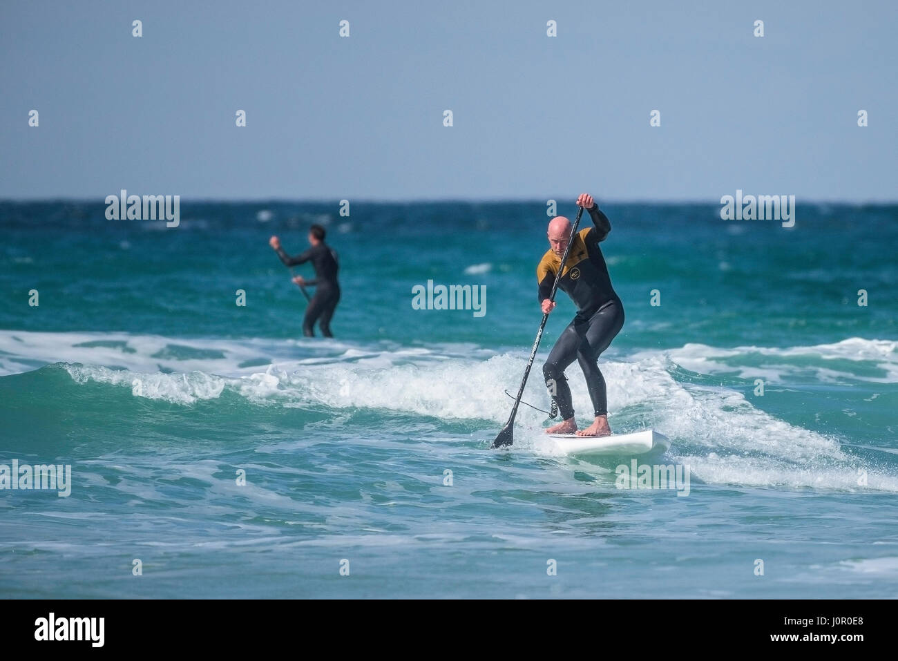 UK-Paddle boarding Paddel Boarder Surf Wave Sea Spray Watersport körperliche Aktivität Skill spektakuläre Action Freizeit Lifestyle Stockfoto