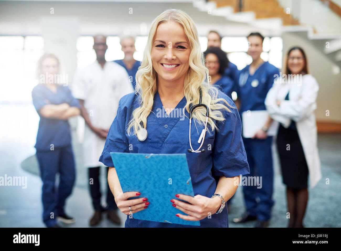 Porträt der schöne blonde Frau in einem Krankenhaus stehen und blickte in die Kamera. Stockfoto