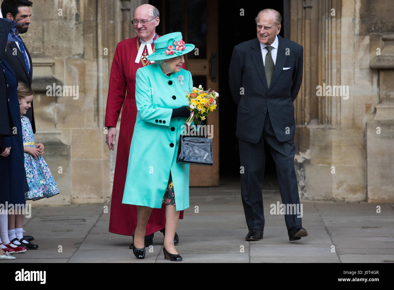 Windsor, UK. 16. April 2017. Die Königin, begleitet von der Duke of Edinburgh und der Dekan von Windsor, Rt Revd David Conner KCVO verlässt St. George Chapel in Windsor Castle mit Blumensträuße Blumen präsentiert ihr von zwei jungen Mädchen, die nach dem Ostersonntag Gottesdienst. Bildnachweis: Mark Kerrison/Alamy Live-Nachrichten Stockfoto