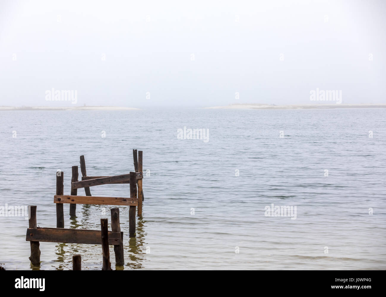 Reste einer alten Dock führenden heraus ins kalte Wasser an einem nebligen Tag im Hampton Buchten, NY Stockfoto