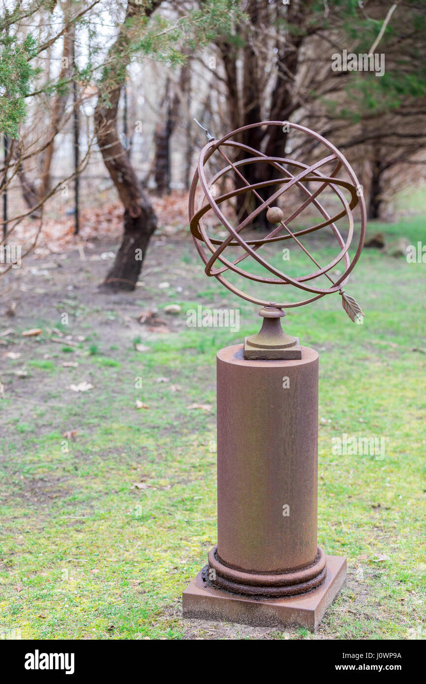 Verwittertem metall Sonnenuhr auf einem Podest in einem Hof Stockfoto