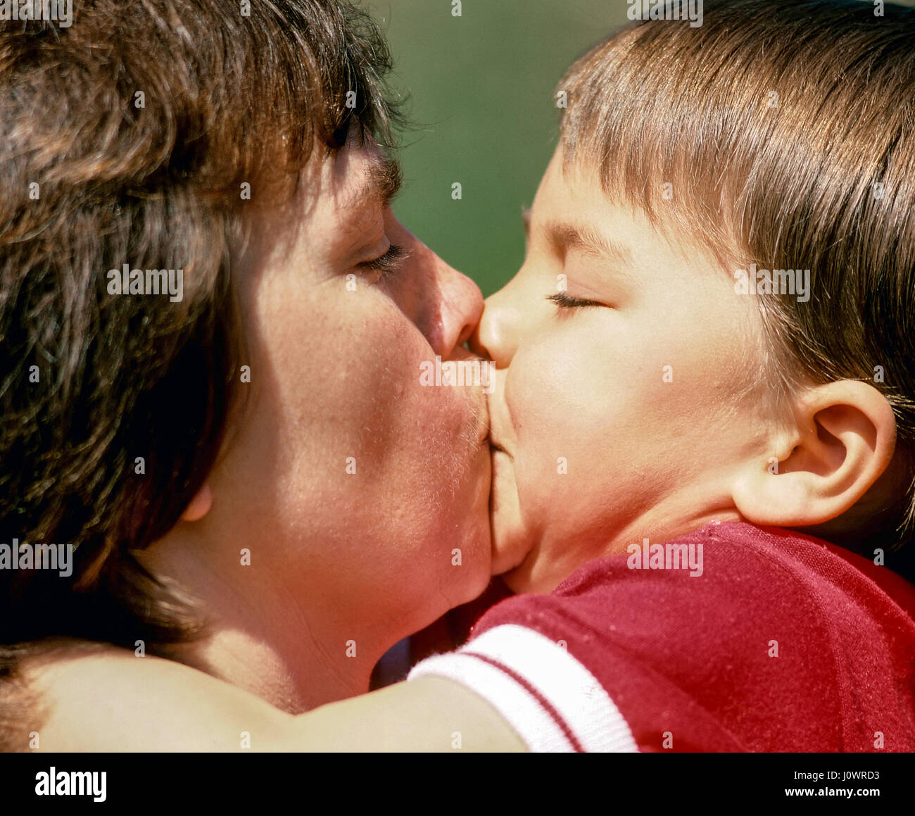 Ein netter dreijährige junge Pflanzen einen großen Kuss auf seine Mutter in Plainfield, New Hampshire, USA. Stockfoto