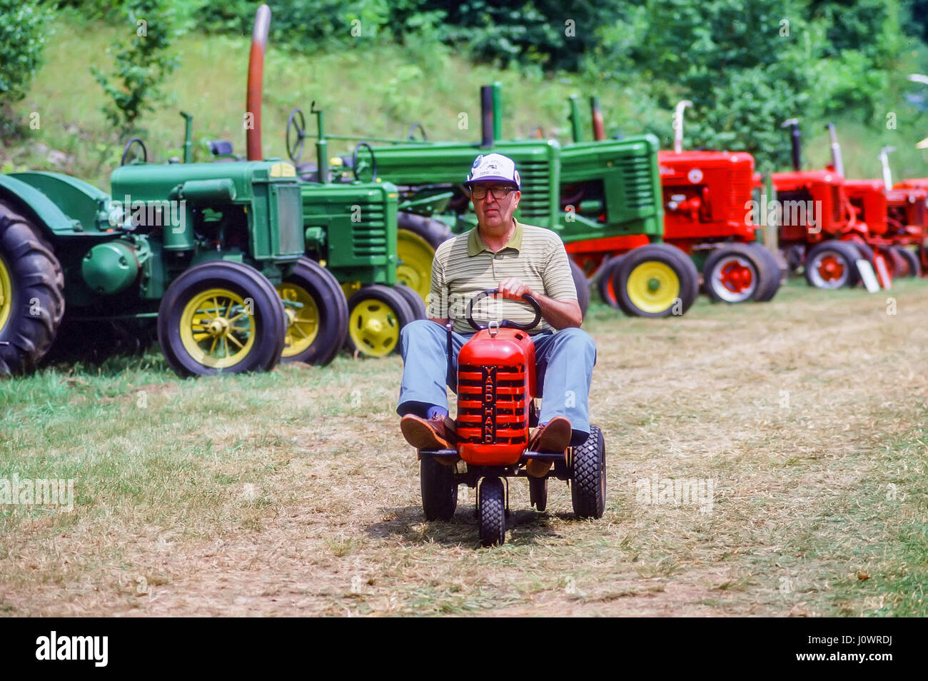 Ein älterer - alter Mann reitet einen kleinen Hof Hand Traktor an der jährlichen Messe in Cornwall Cornwall, New Hampshire, USA statt. Stockfoto