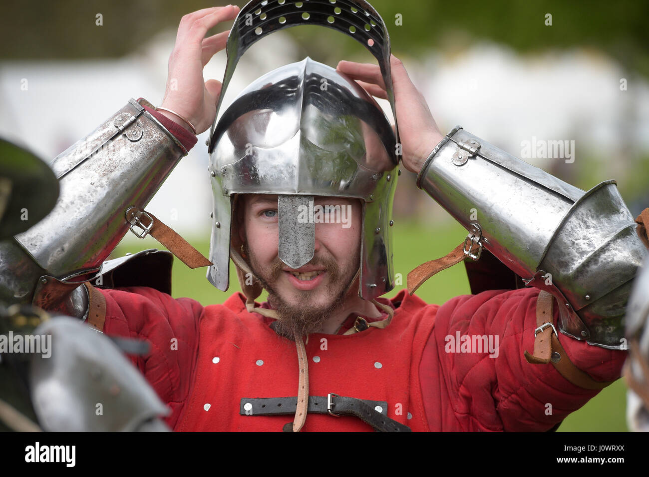 Ein Mann stellt seinen Helm in Vorbereitung auf eine Schlacht bei Glastonbury mittelalterlichen Wochenende, Abtei von Glastonbury, Somerset. Stockfoto