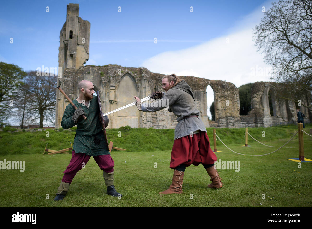 Menschen üben Angriff und defensive Bewegungen vor der Glastonbury Abbey Ruinen in Vorbereitung auf eine Schlacht bei Glastonbury mittelalterlichen Wochenende, Abtei von Glastonbury, Somerset. Stockfoto