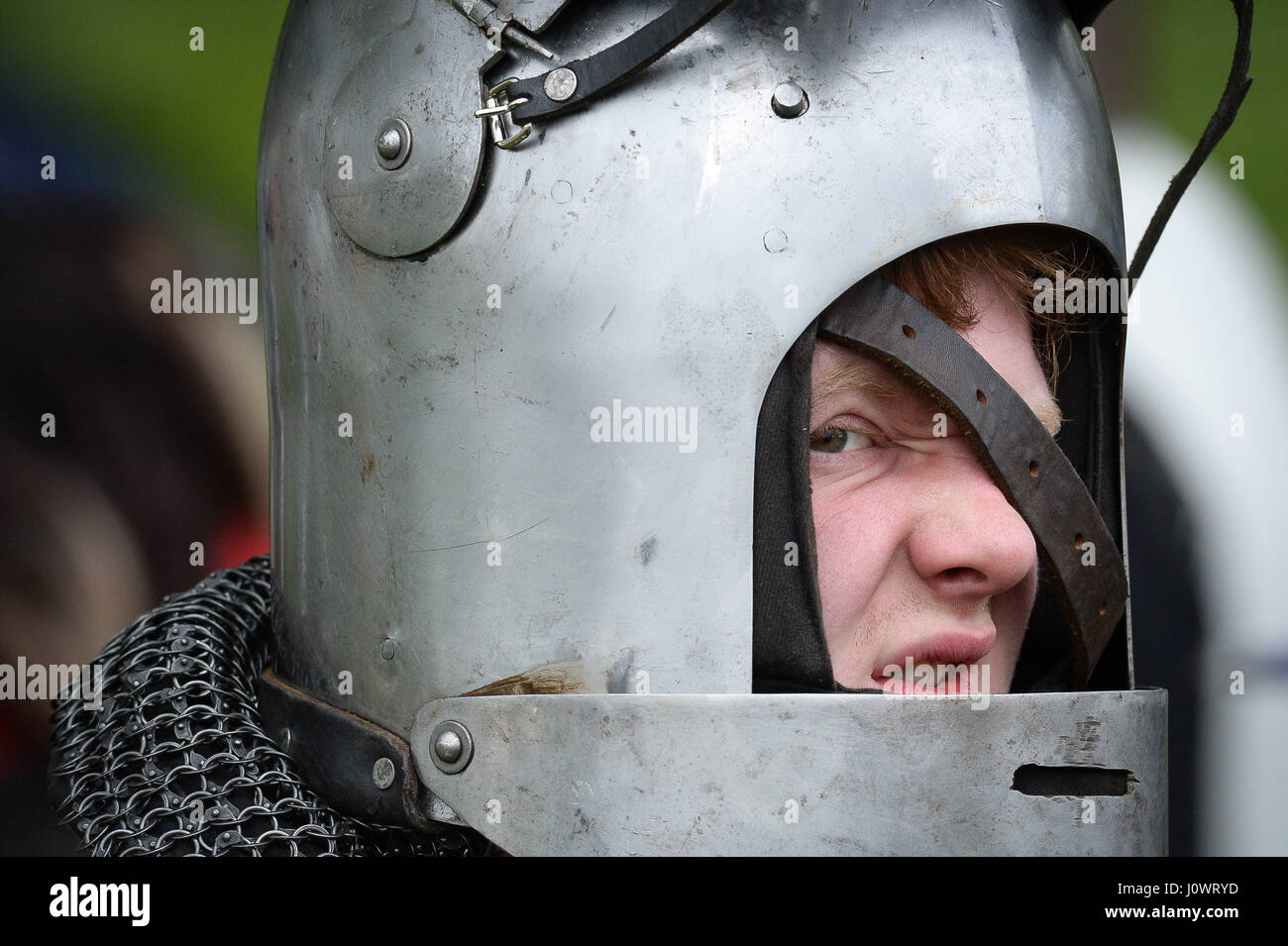 Ein Mann kämpft setzen auf seinem Helm in Vorbereitung auf einen Kampf der mittelalterlichen Glastonbury Wochenende, Abtei von Glastonbury, Somerset. Stockfoto