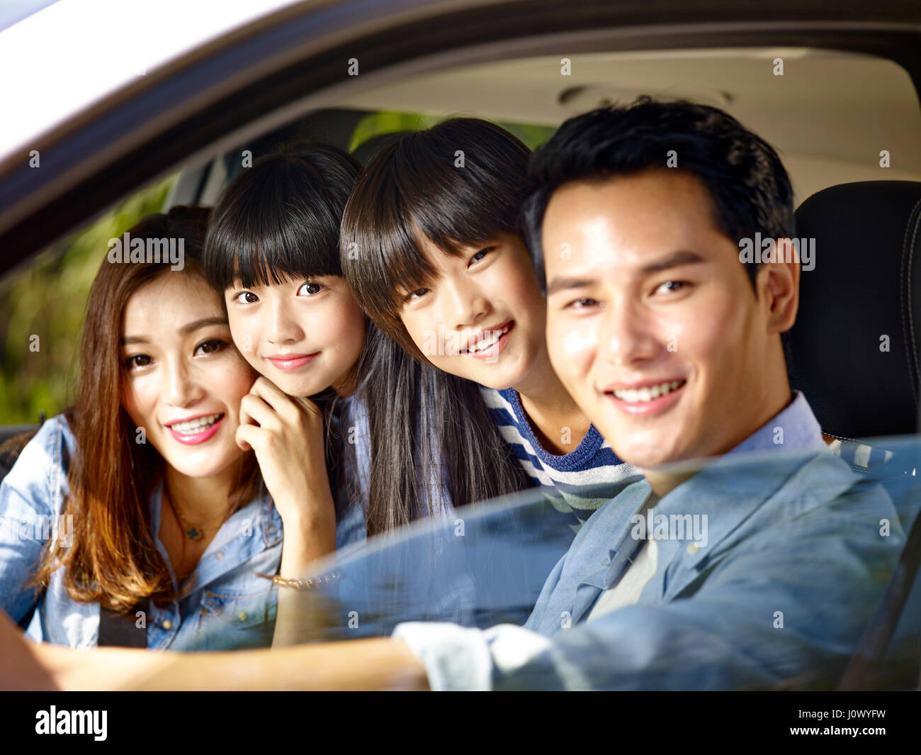 glückliche asiatischen Familie mit zwei Kindern in einem Auto fahren Stockfoto