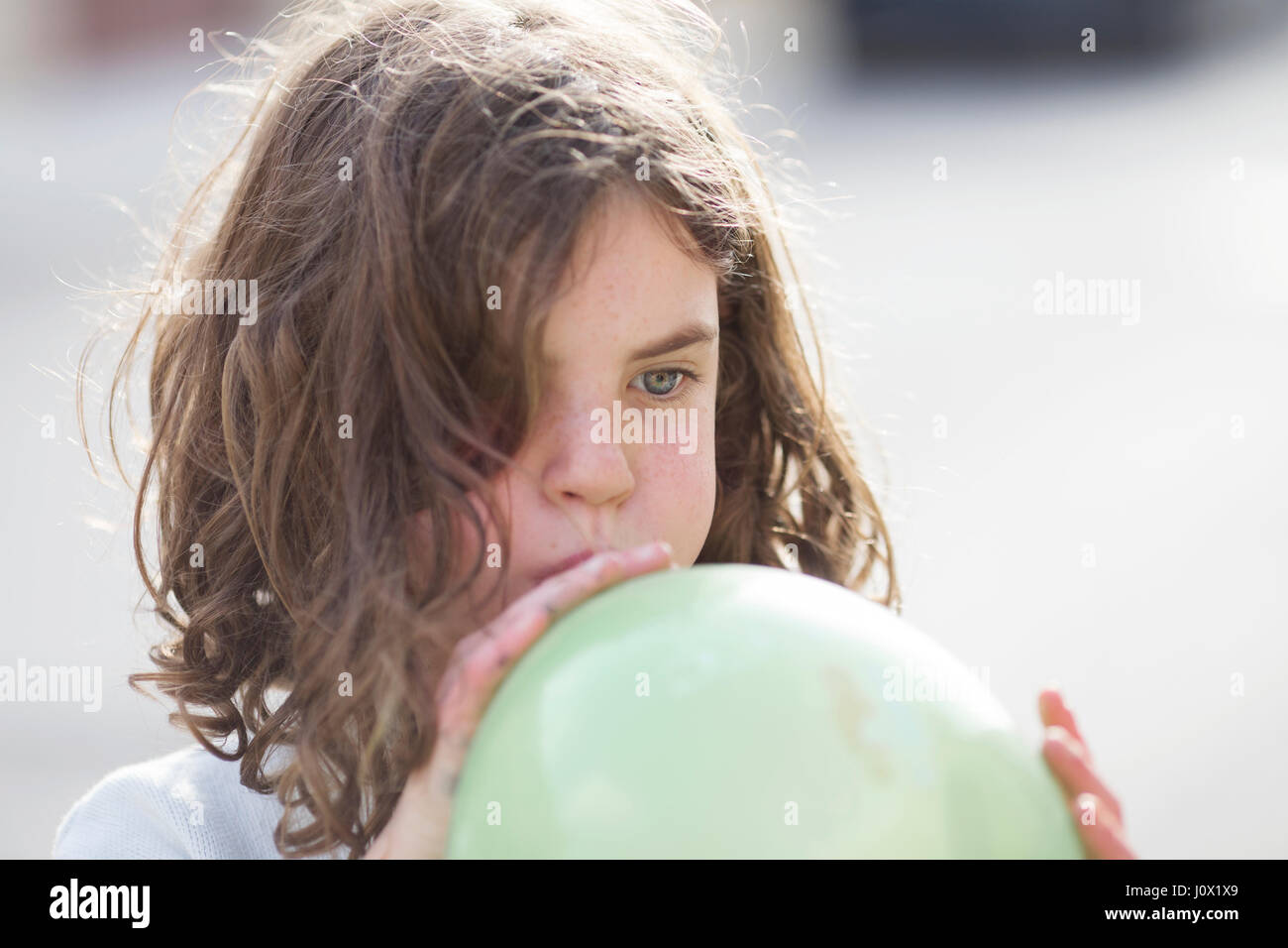 Mädchen bläst einen Ballon Stockfoto