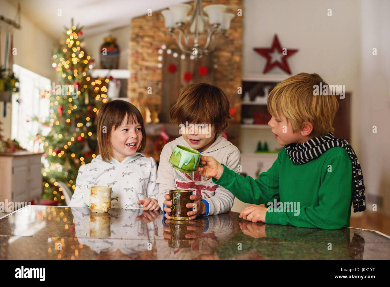 Drei Kinder trinken heißen Schokolade zu Weihnachten Stockfoto