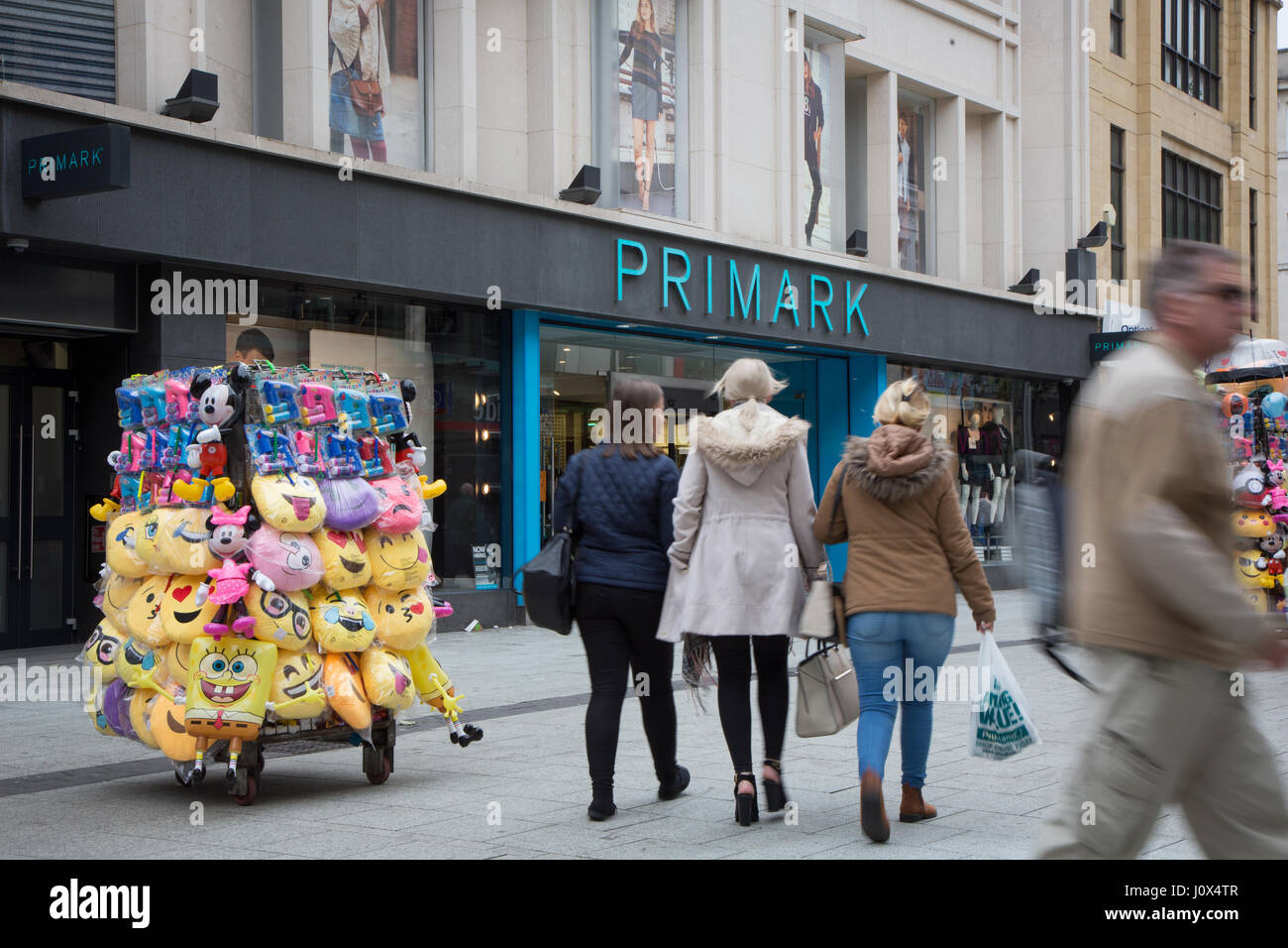Primark auf Queen Street, Cardiff. Händler im Vordergrund sind Emoji Kissen etc. verkaufen. Stockfoto