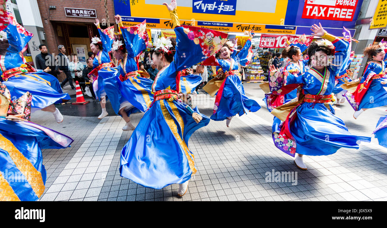 Hinokuni Yosakoi Dance Festival. Frauen Mannschaft in Blau und Rot yukata, Bildung tanzen und wirbelnden gelbe Kleidung, im Einkaufszentrum. Stockfoto
