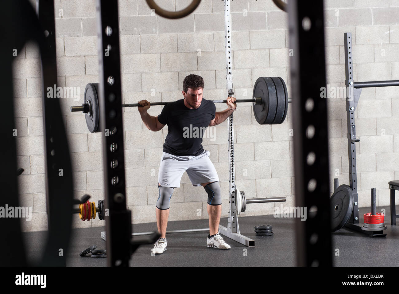 Bodybuilder trainieren auf squat Rack im Fitness-Studio, Gewicht Ausrüstung im Vordergrund Stockfoto