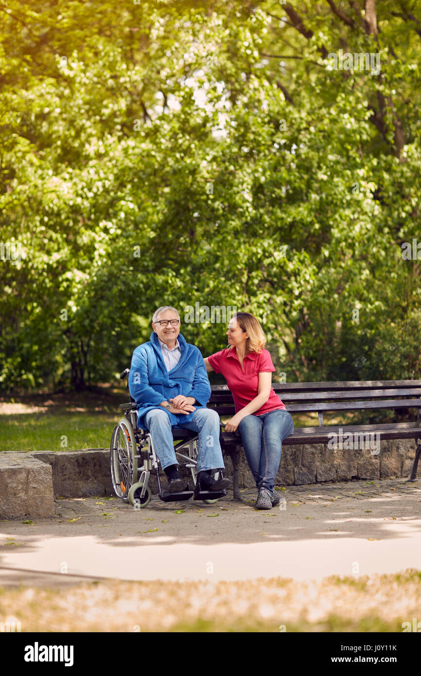 Zeit miteinander zu verbringen fröhliche Tochter mit ihrem behinderten Vater im Rollstuhl in den Park Stockfoto