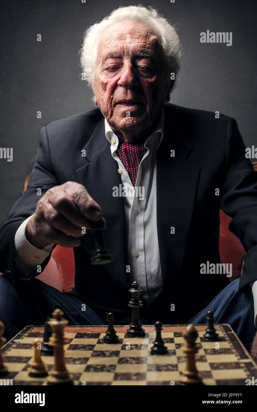 Alter Mann spielt Schach Stockfoto