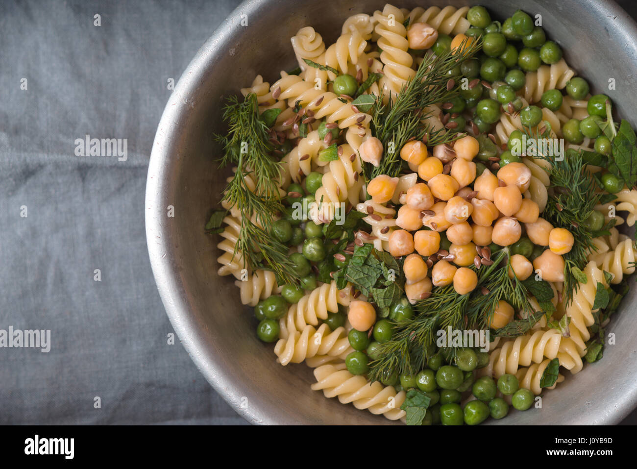 Salat mit Fusilli, Kichererbsen und Erbsen in einer Metallschüssel ...